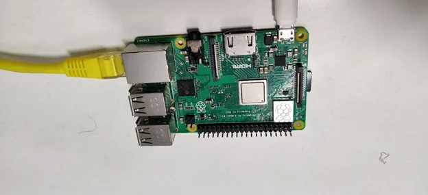 Raspberry Pi 3 board with a yellow Ethernet cable plugged in