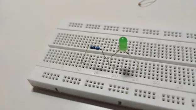 Green LED and a resistor inserted into a breadboard